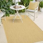 Patio setting met witte meubels en groene planten voor ontspanning en sociale bijeenkomsten.